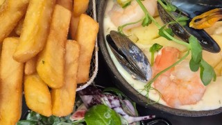 mussels and prawn dish with chips and salad