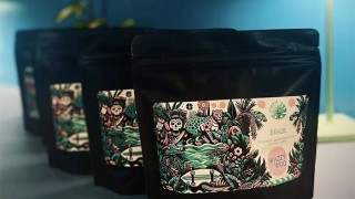 Packets of ground coffee beans decorated with colourful illustrations and the Wazzy Woo branding