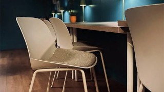 The interior of Wazzy Woo - a long wooden table up against a wall lined with white chairs