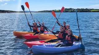 Kaying group with paddles raised in the air